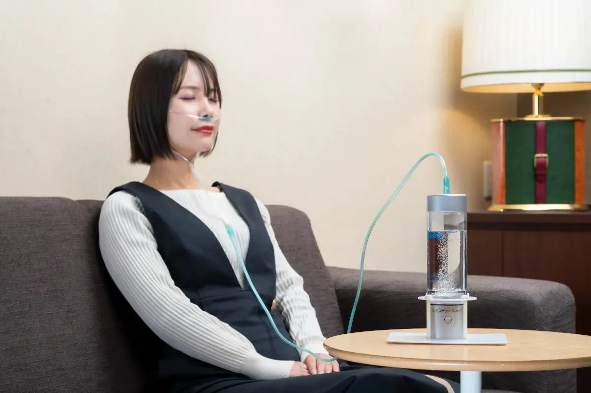 室内で水素吸入をする女性